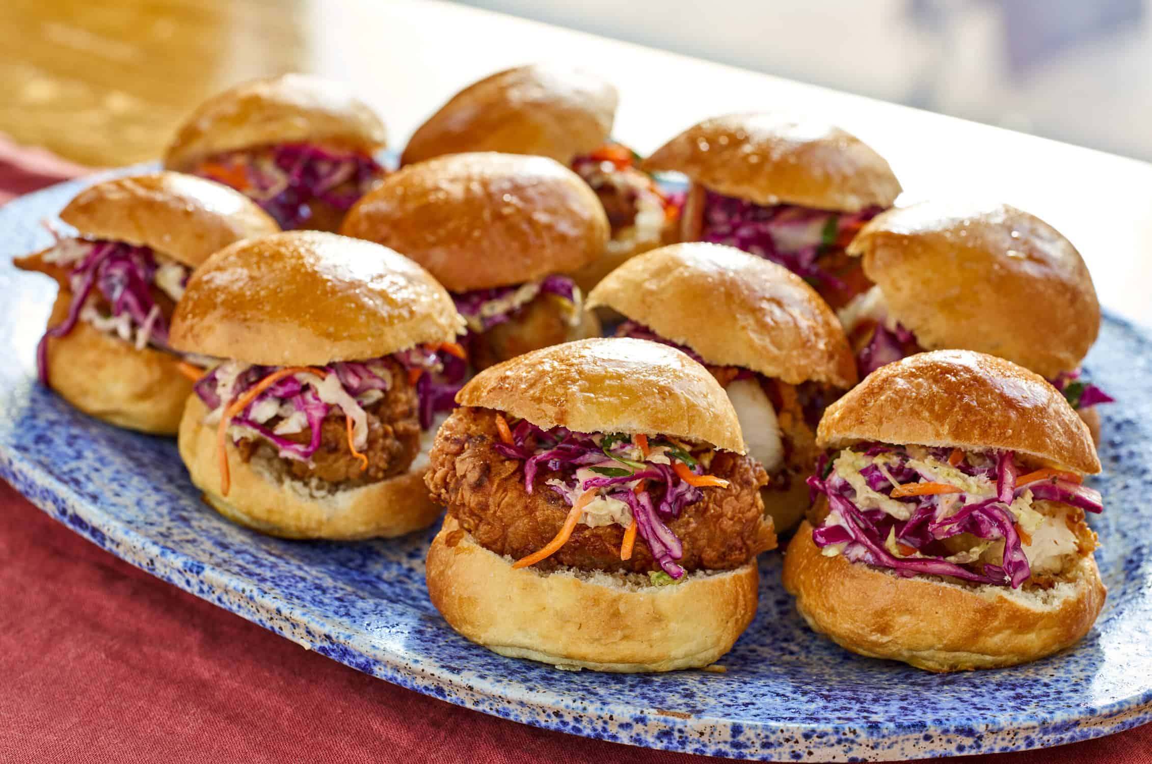 a tray of Huckleberry's famous fried chicken sliders with cole slaw and brioche buns